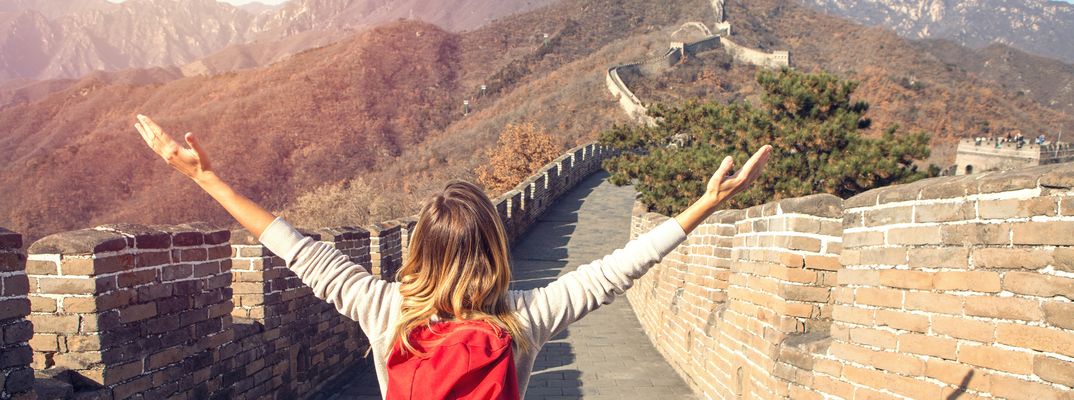 Eine Frau wandert entlang der Chinesischen Mauer