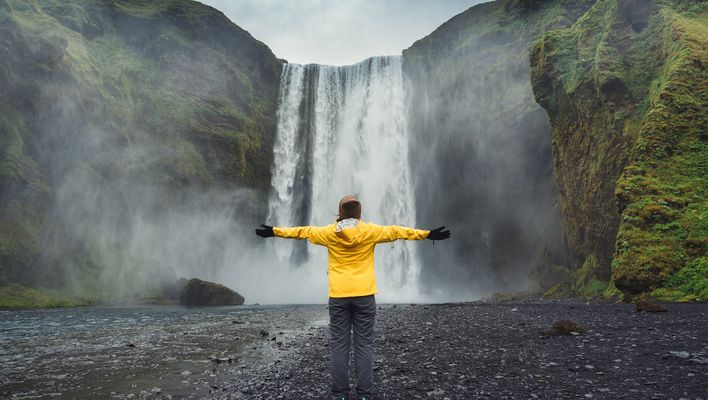 Frau vor Wasserfall auf Island