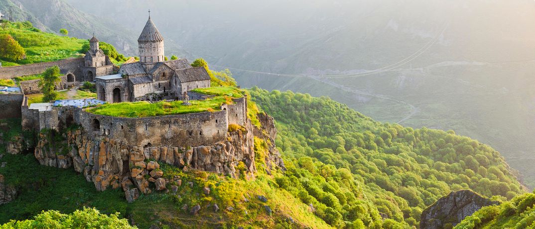 Das Kloster Tatew eingebettet in eine grüne Gebirgslandschaft in Armenien