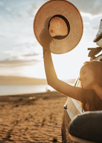 Frau im Auto am Meer