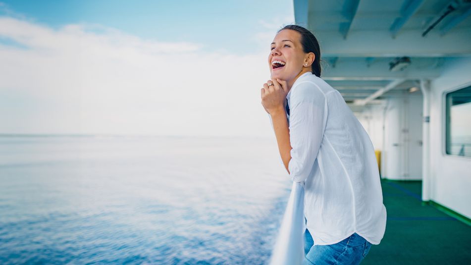 Fröhliche Frau auf Kreuzfahrtschiff