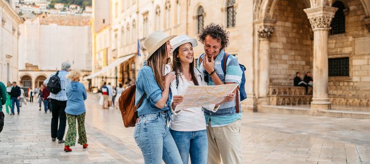 Freunde erkunden die Stadt Dubrovnik mit einem Stadtplan in der Hand