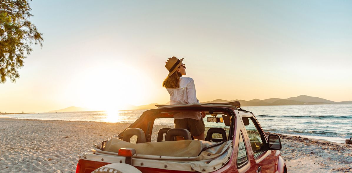 Frau blickt aus dem Auto auf das Meer