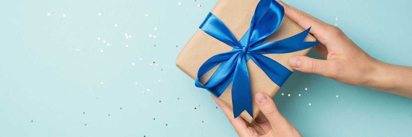 Hände halten eingepacktes Geschenk