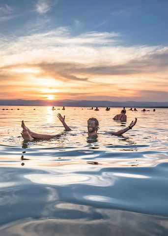 Menschen schwimmen im salzreichen Wasser des Toten Meeres