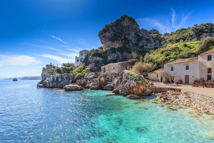 Kleine Bucht mit Häusern und glitzerndem Meer in Scopello auf der italienischen Insel Sizilien