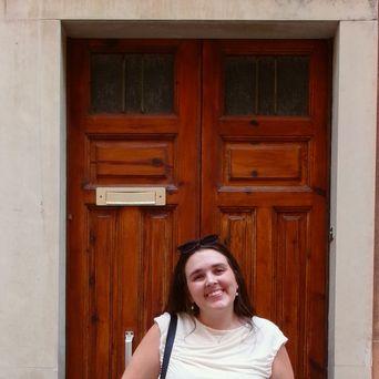 Mitarbeiterin Jana vor einer Tür bei einem Spaziergang durch Ragusa, Sizilien