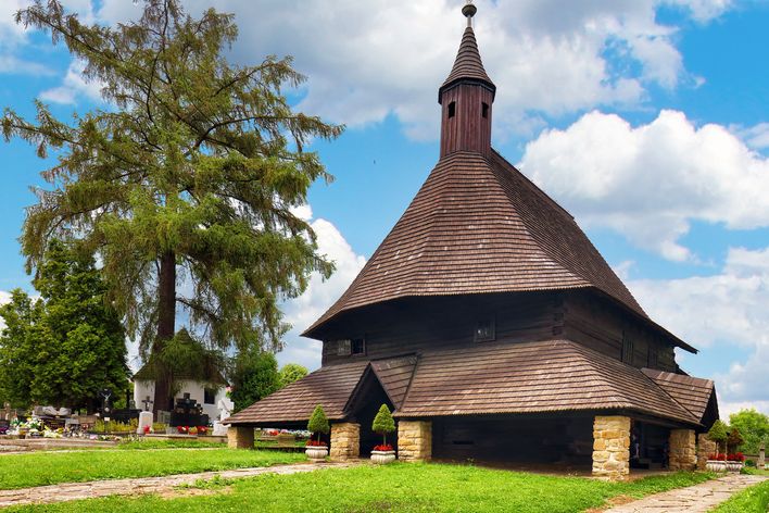 Holzkirche von Orava in der Slowakei mit traditioneller Bauweise und Wiesen
