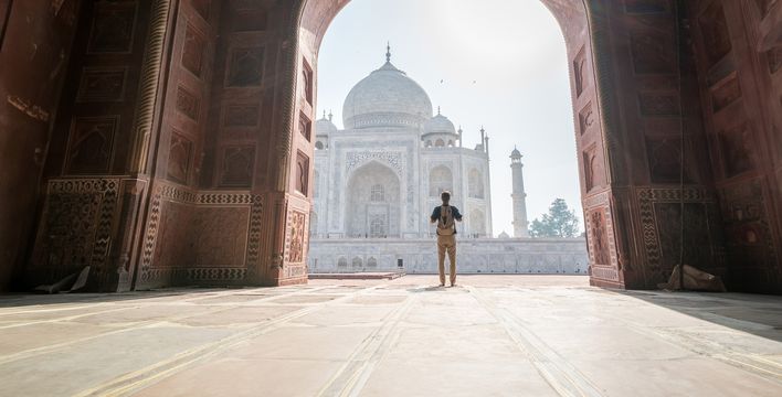 Mann steht im Torbogen mit Blick auf den Taj Mahal