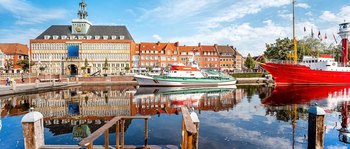 Historisches Rathaus und Hafen von Emden mit bunten Booten