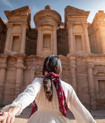 Eine Frau läuft auf die prächtige Felsenkammer in Petra zu, Jordanien