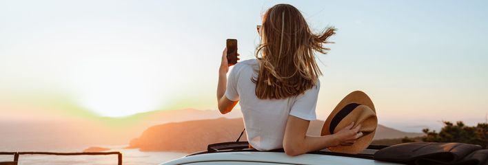 Frau mit Handy im Auto