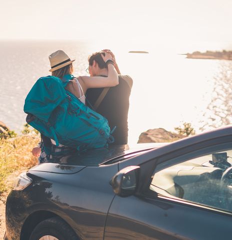 Paar am Auto an der Küste