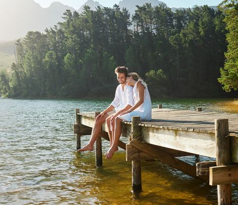 Paar sitzt auf Steg am See