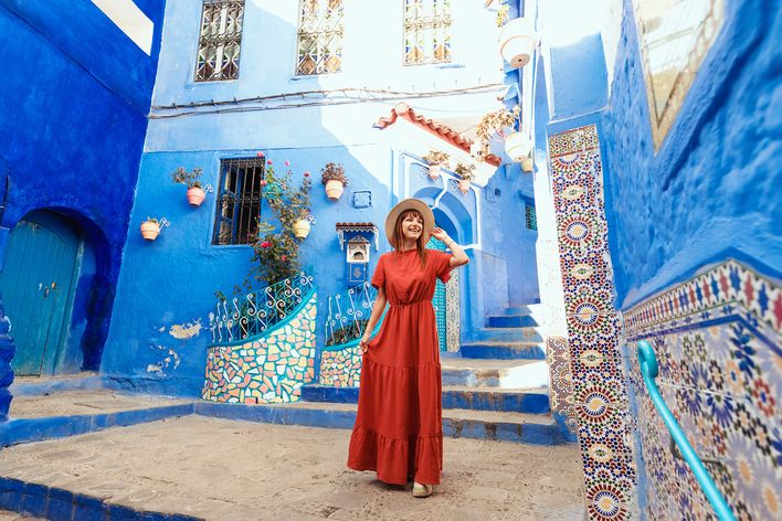 Frau spaziert durch die blauen Gassen von Chefchaouen in Marokko