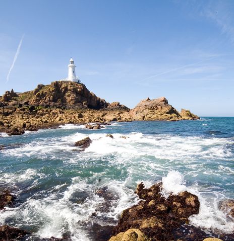 Felseninsel und Leuchtturm vor der Küste von Jersey im Atlantik