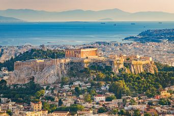 Weite Sicht auf das antike Bauwerk Akropolis in Athen in Griechenland mit weitem Ausblick auf die Stadt und das Meer