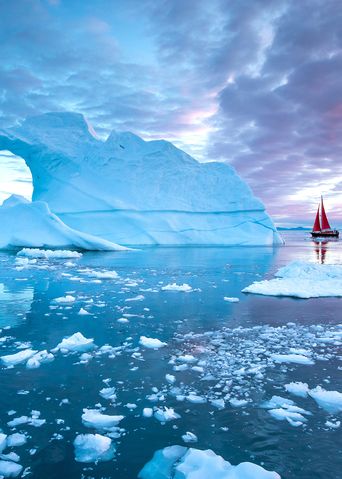 Ein Boot fährt an einem Eisberg vorbei