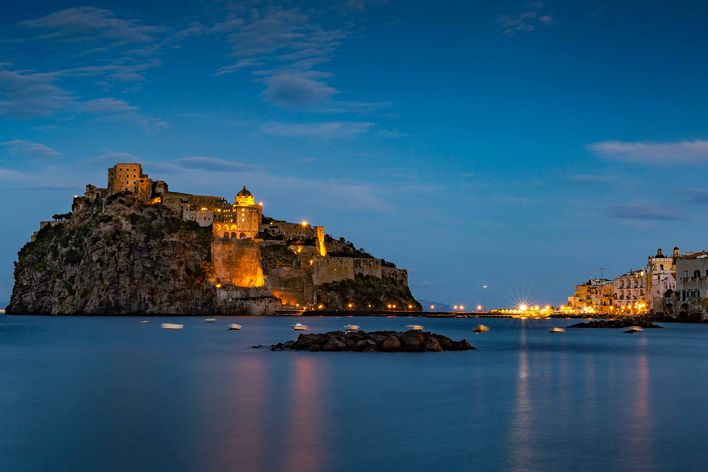 Blick auf das Castello Aragonese bei Nacht.