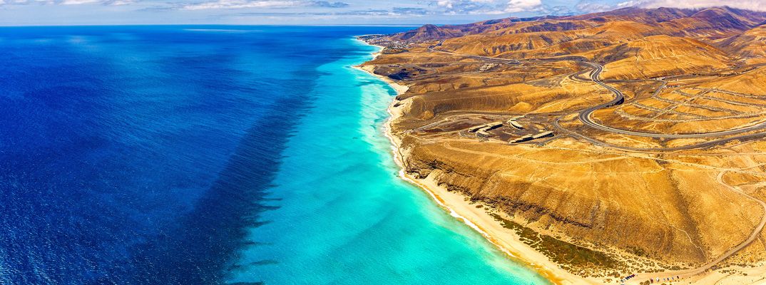 Goldgelber Sandstrand mit türkisfarbenem Wasser am Playa de Sotavento auf Fuerteventura