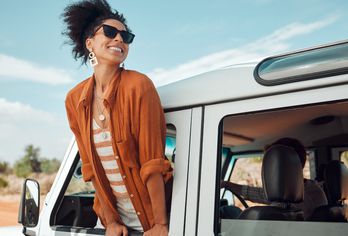 Eine Frau schaut aus dem Fenster eines Autos in die Landschaft