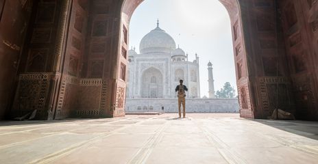Mann unter einem Torbogen vor dem Taj Mahal in Indien