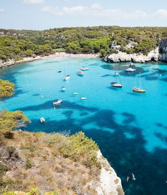 Blick auf Strand und Felsen in der Bucht Cala Macarelleta auf den Balearen auf Menorca in Spanien