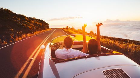 Paar gemeinsam in einem Cabrio auf der Straße