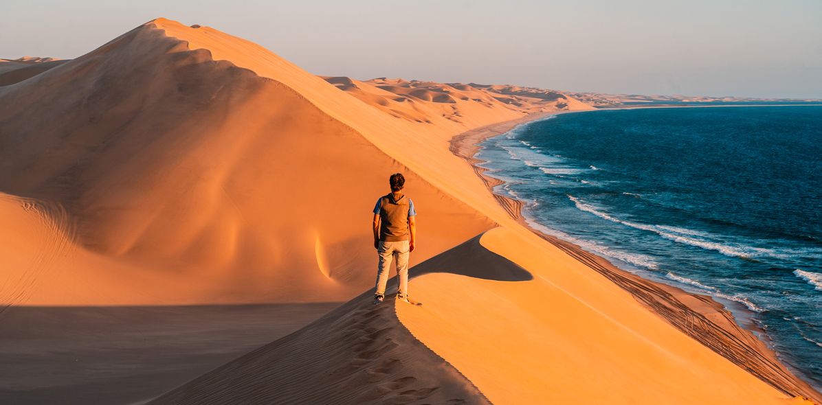 Mann auf Dünen in Namibia