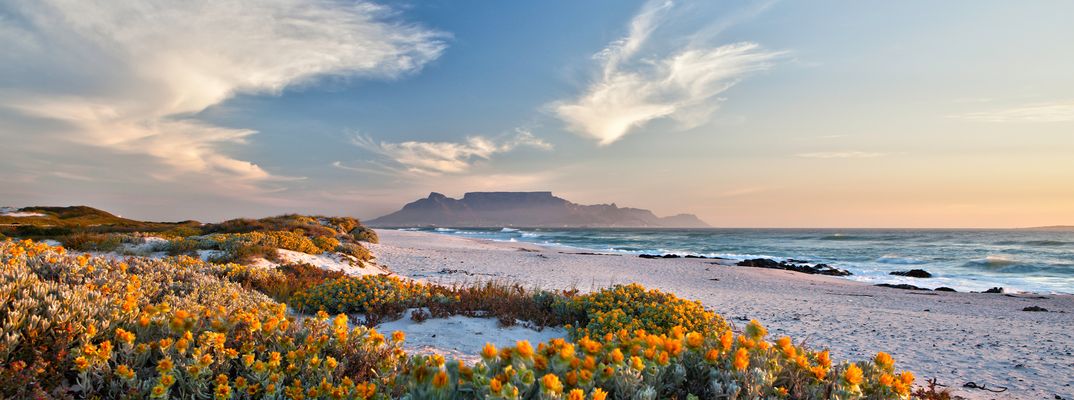 Blick auf einen Strandabschnitt mit Blick auf Kapstadt und Tafelberg