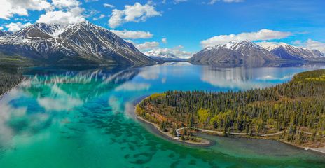 Flusslandschaft im Yukon mit smaragdgrünem Wasser und bewaldeten Hügeln