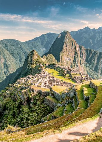 Panoramablick auf Machu Picchu mit Serpentinenweg und grünen Berghängen