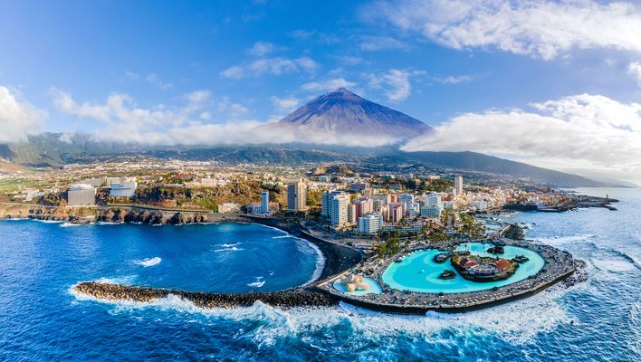Blick auf den Ort Puerto de la Cruz mit Meerwasserpool und dem Teide im Hintergrund auf Teneriffa