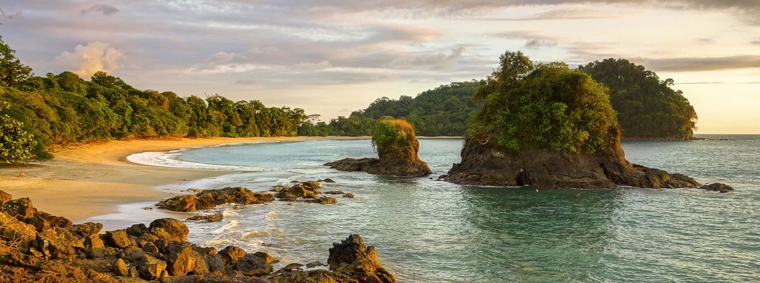 Tropischer Strand im Manuel-Antonio-Nationalpark in Costa Rica mit Felsen und Palmen