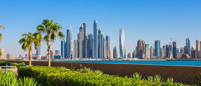 Dubai Skyline mit Palmen, Grünflächen und moderner Architektur