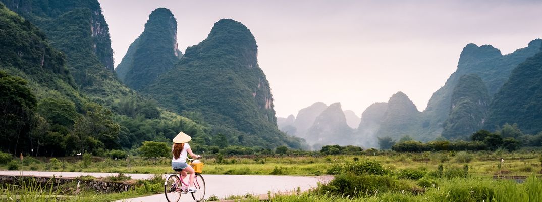 Radfahrerin in einer typischen chinesischen Landschaft