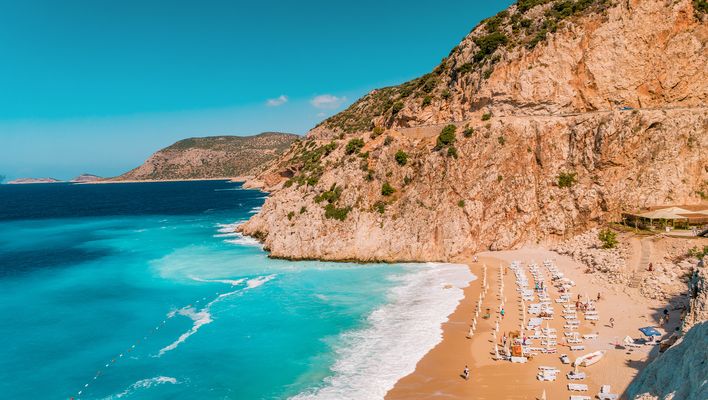 Beliebter Kaputaş Strand mit türkisfarbenem Meer, hellem Sand und steiler Küste