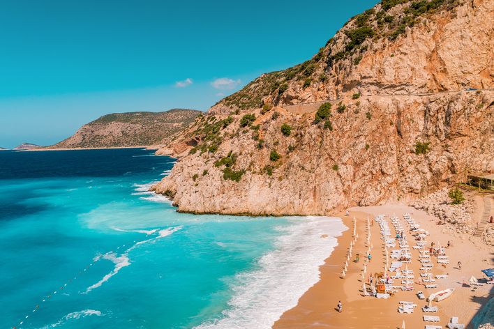 Beliebter Kaputaş Strand mit türkisfarbenem Meer, hellem Sand und steiler Küste