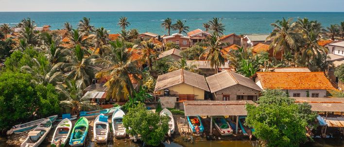Luftaufnahme des Hafens von Negombo mit bunten Fischerbooten und Häusern an der Westküste Sri Lankas