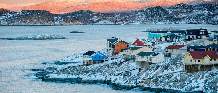 Blick auf Ilulissat mit Eisfjord, Booten und schneebedeckten Hügeln