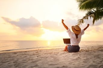 Frau mit Laptop am Strand