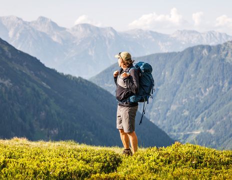 Mann genießt den Ausblick bei einer Wanderung in Österreich