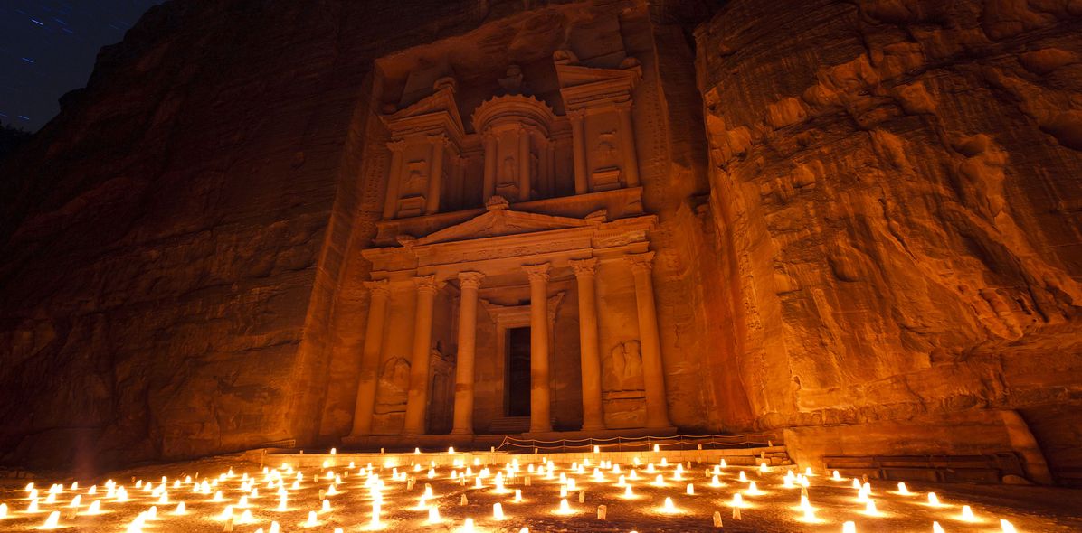 Lichter vor der Felsenstadt Petra in Jordanien in der Nacht