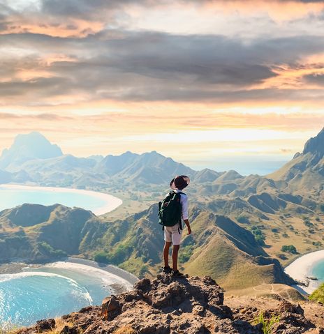 Mann mit Rucksack blickt im Komodo-Nationalpark auf der Insel Padar in Indonesien