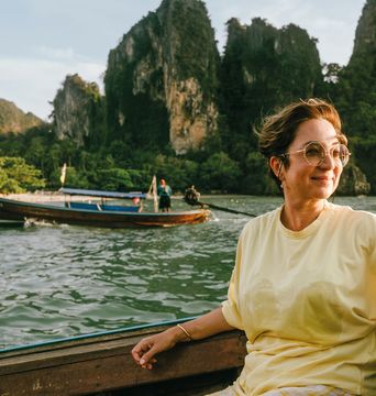 Frau genießt eine Bootsfahrt vor den Kalksteinfelsen der thailändischen Inselwelt bei Krabi