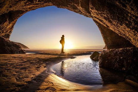 Mann in Höhle vor Sonnenuntergang