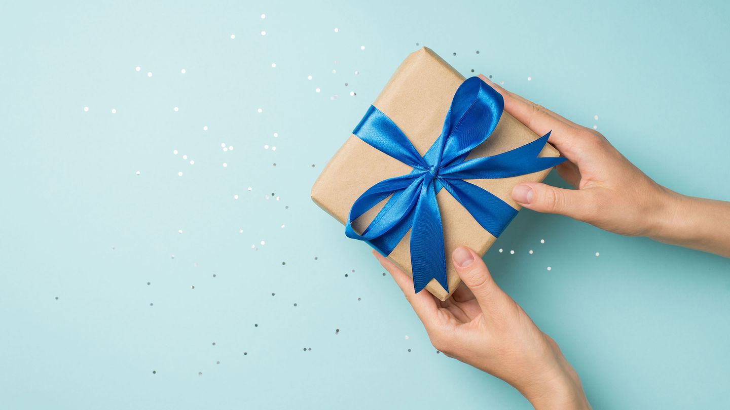 Hände halten eingepacktes Geschenk