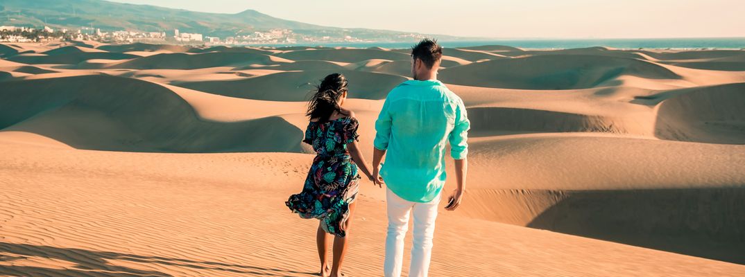 Paar spaziert über die goldenen Sanddünen von Maspalomas auf Gran Canaria