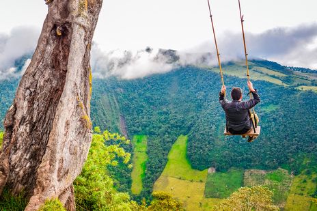 Schaukel am Rand der Schlucht von Baños mit Blick auf grüne Berge