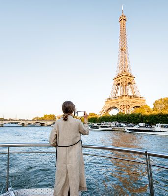 Frau auf einem Flusskreuzfahrtschiff fotografiert den Eifelturm in Paris